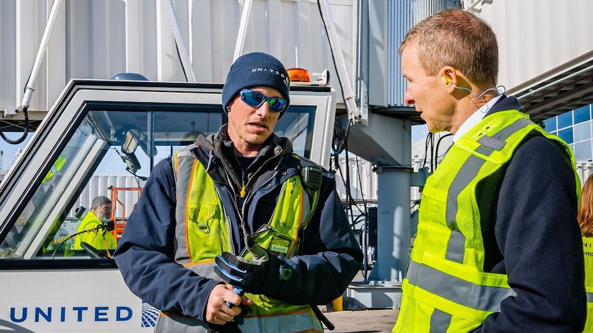 a man in safety vests talking to another man