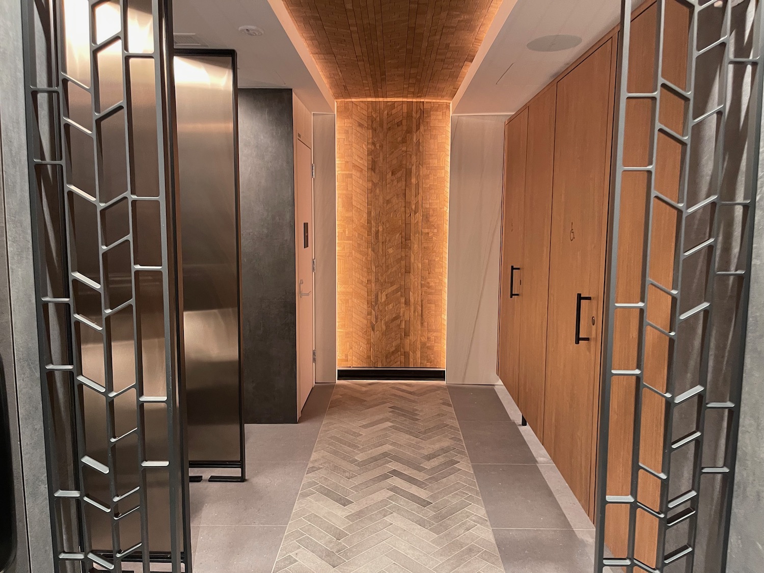 a hallway with wooden doors and a metal gate