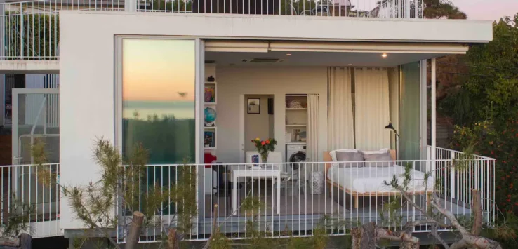 a white house with a balcony and a bed