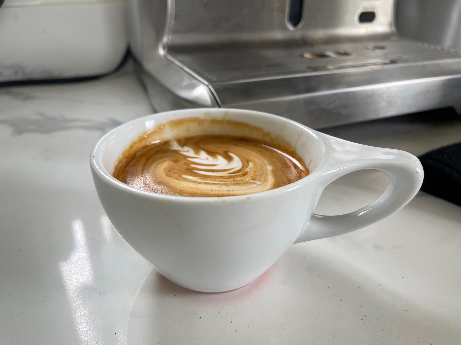 a cup of coffee with a swirl of brown liquid in it