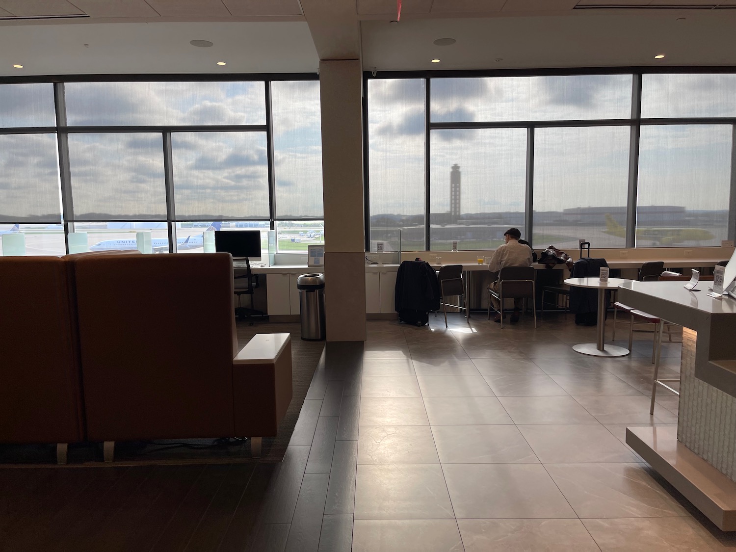 a room with a large window and a man sitting at a table