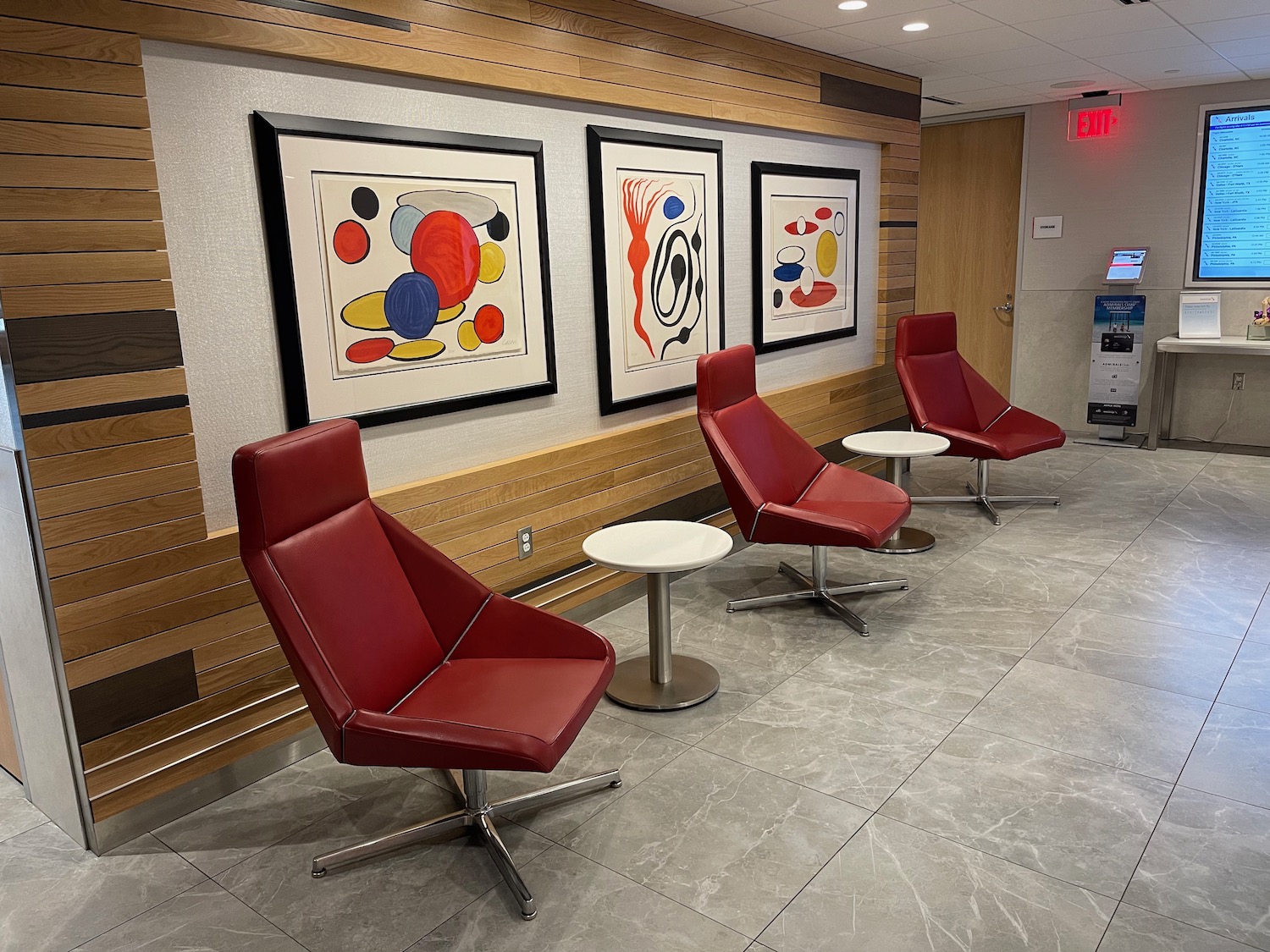 a group of chairs and tables in a room with art on the wall