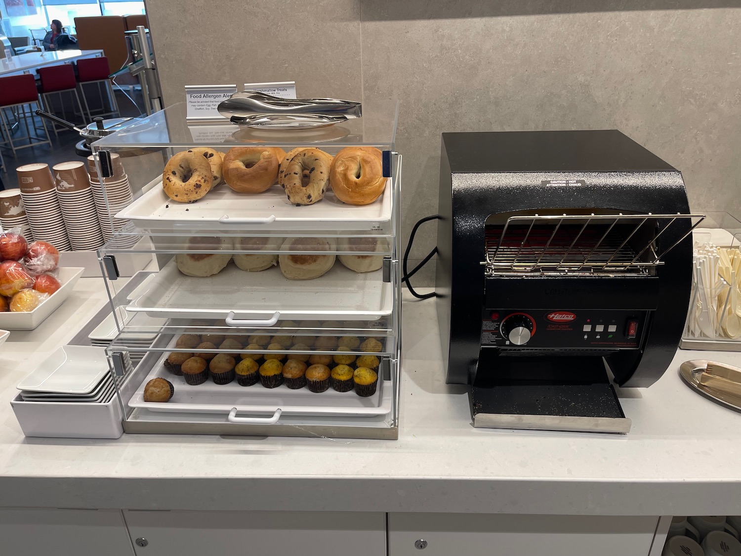a tray of bagels and cupcakes on a counter