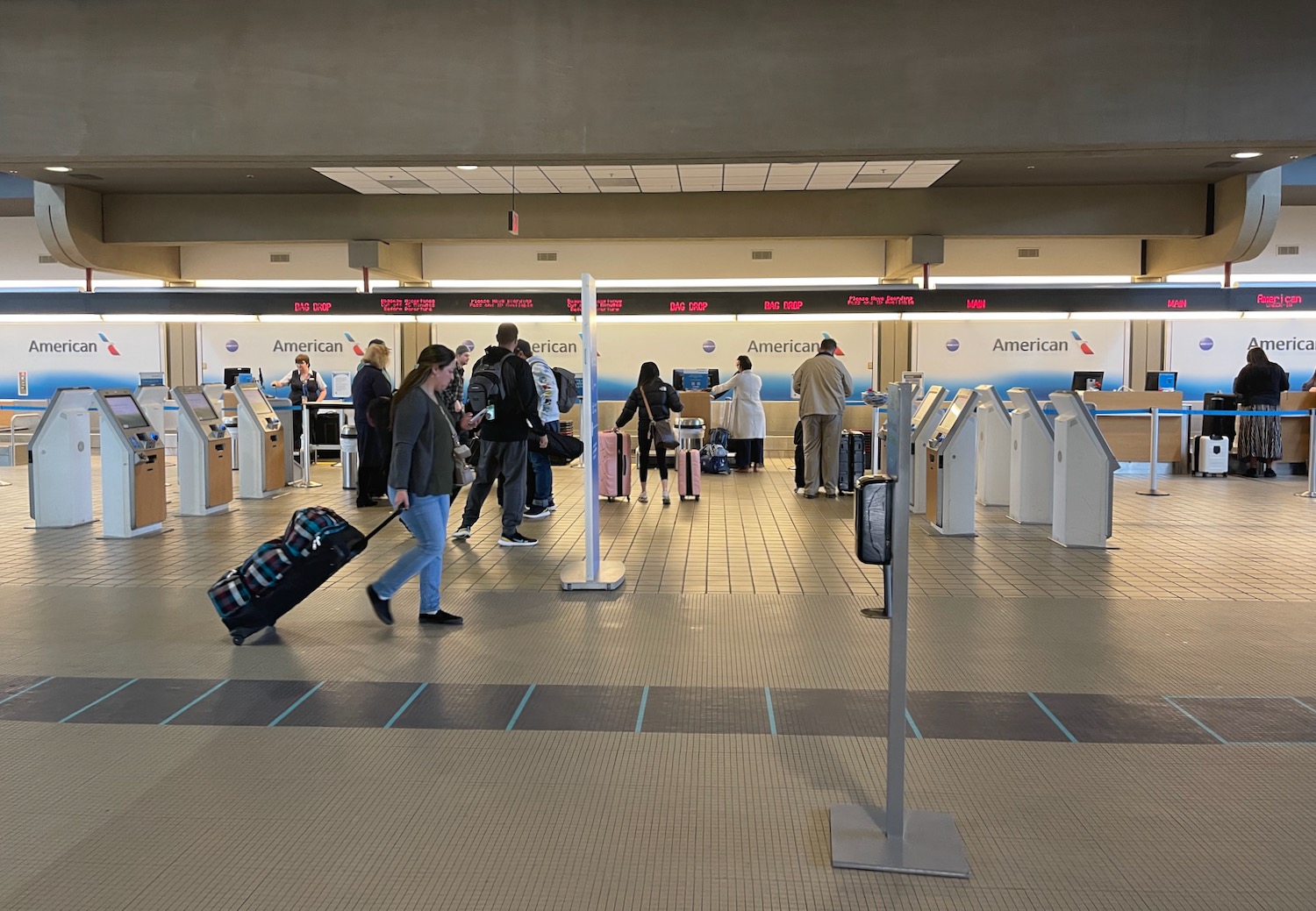 people walking with luggage in an airport