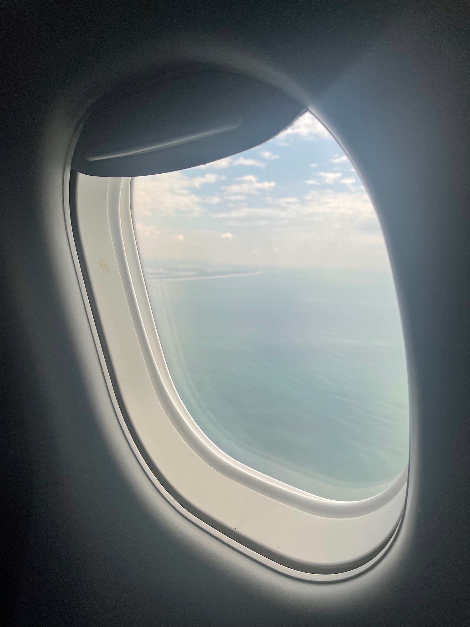 an airplane window with a view of the ocean