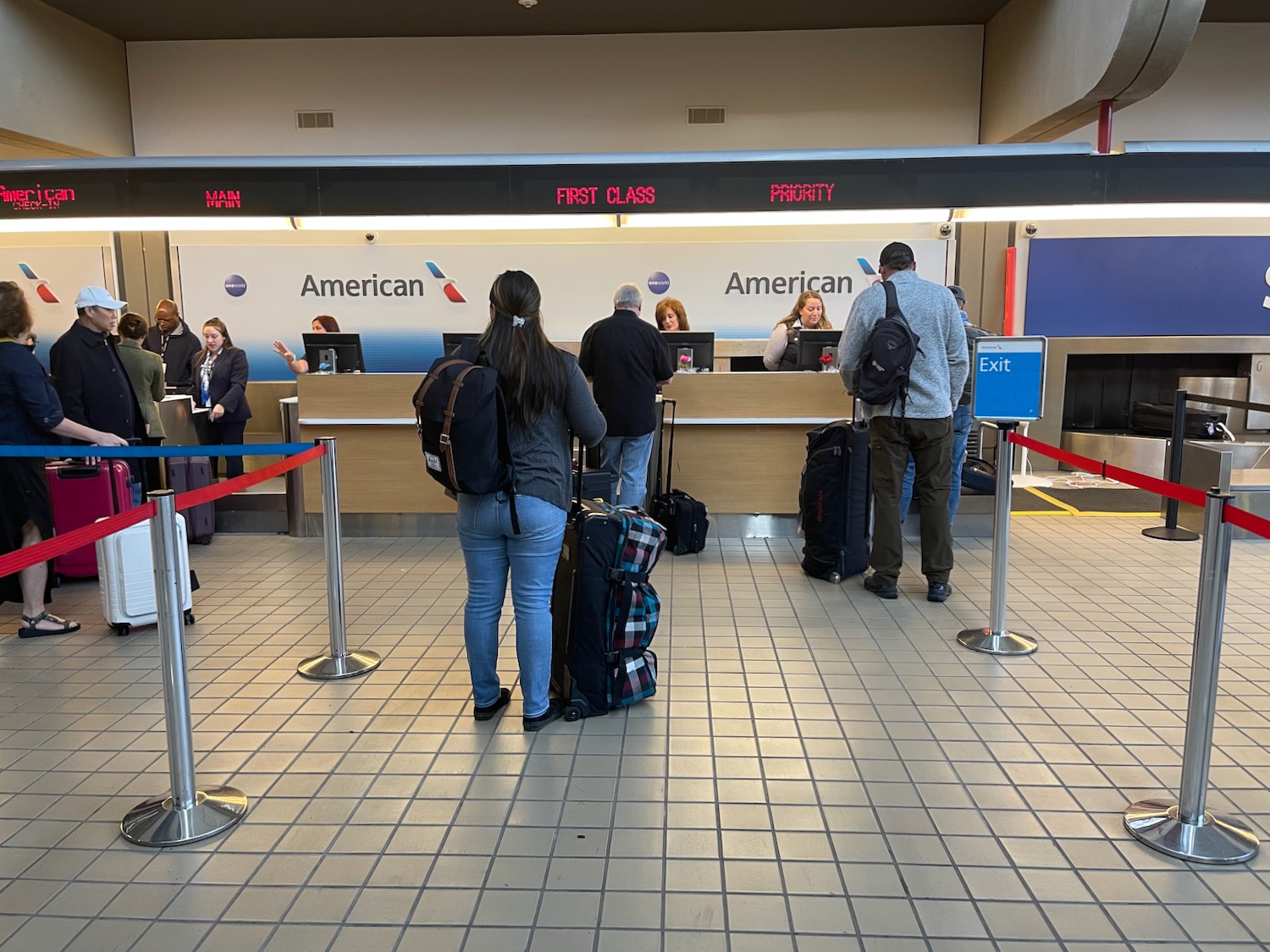 people standing in front of a counter with luggage