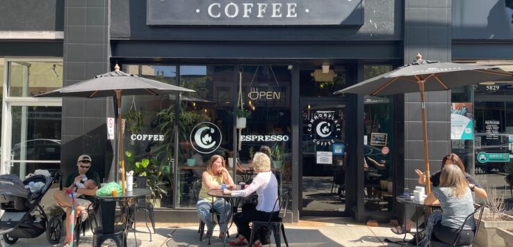 a group of people sitting outside a coffee shop