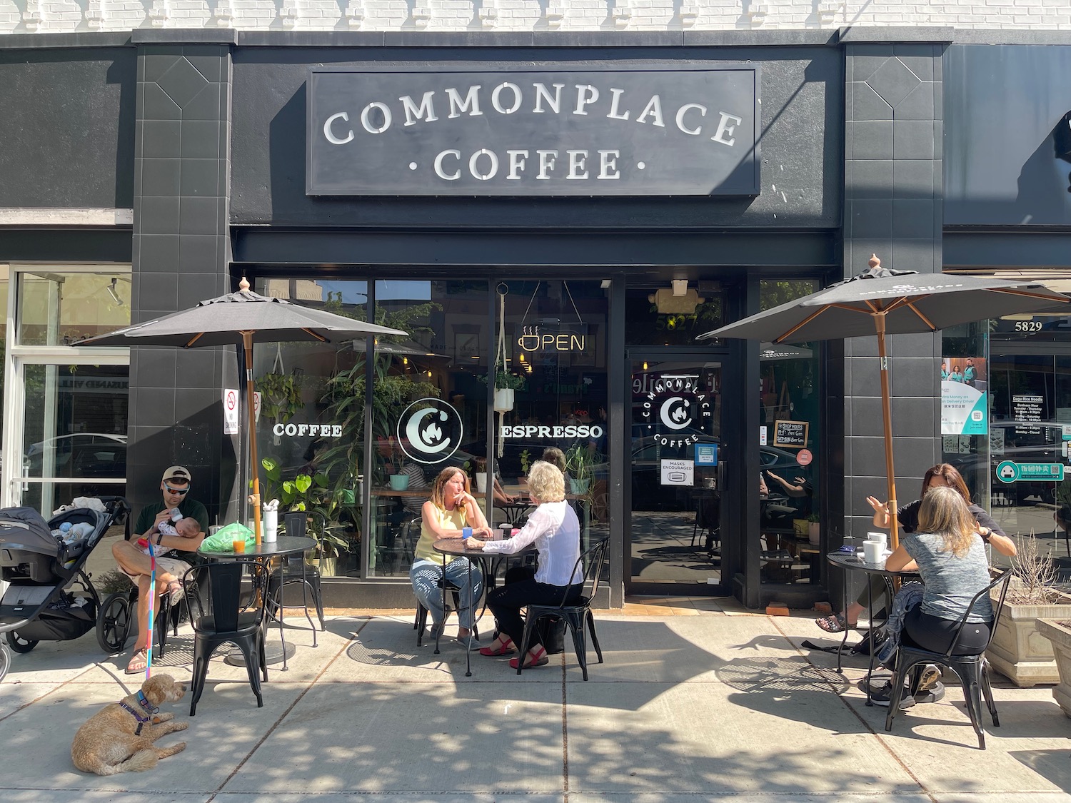 a group of people sitting outside a coffee shop