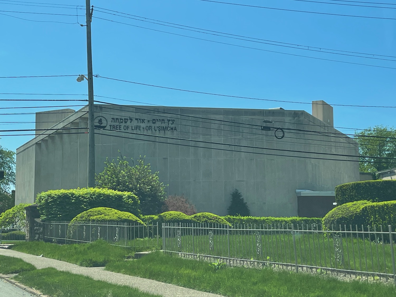 a building with a fence and bushes