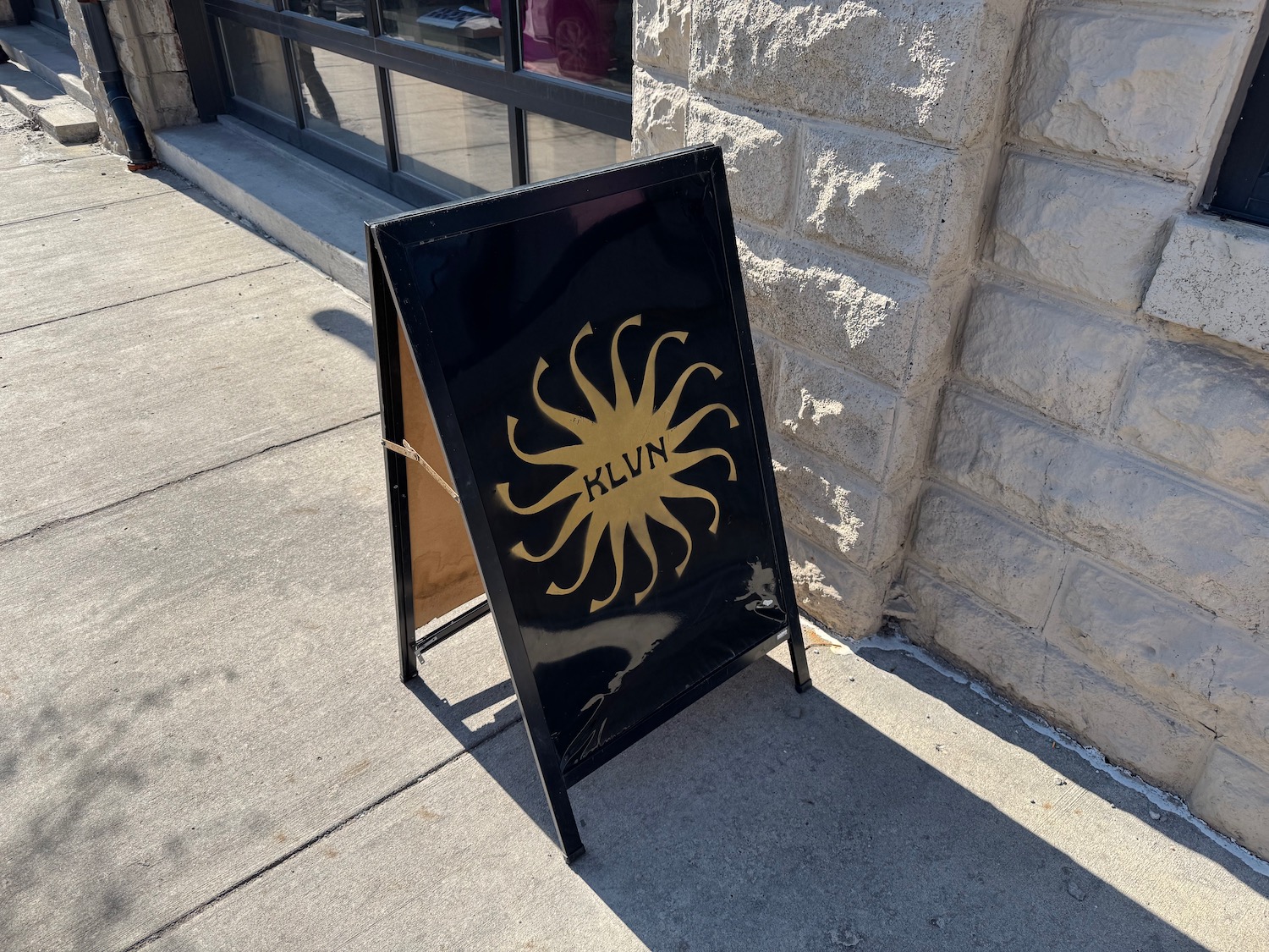 a black sign with a yellow sun on it