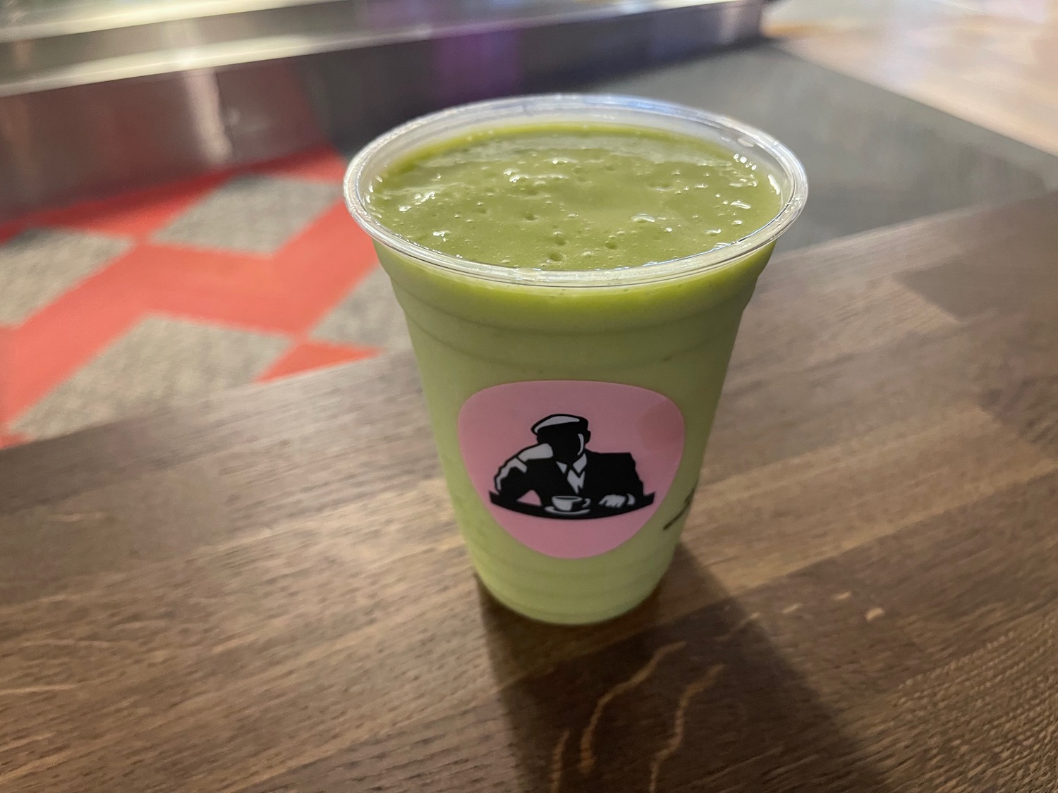 a green smoothie in a plastic cup