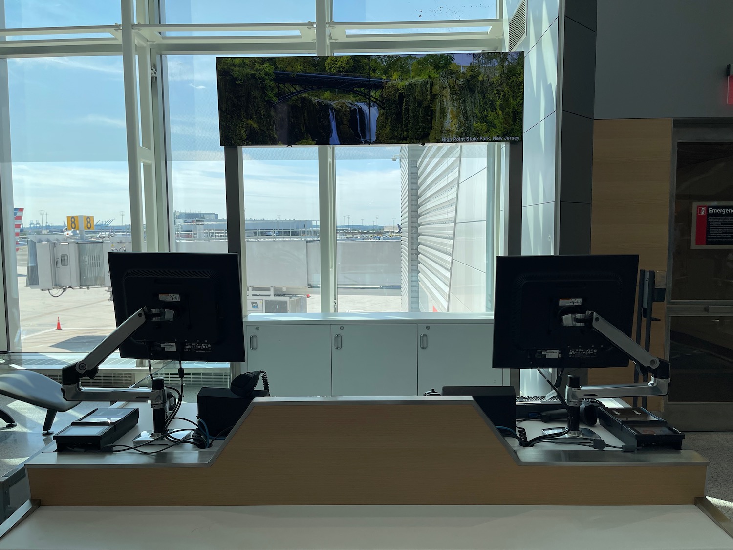 a desk with computers in front of a window