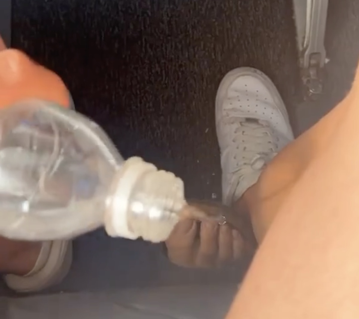 a person spraying liquid onto a person's leg