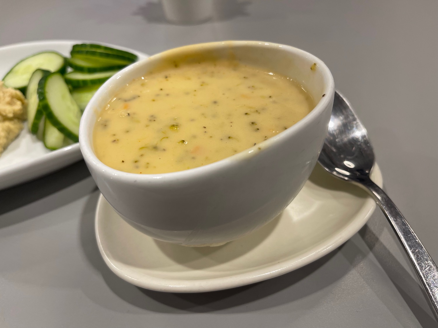 a bowl of soup and a plate of cucumbers