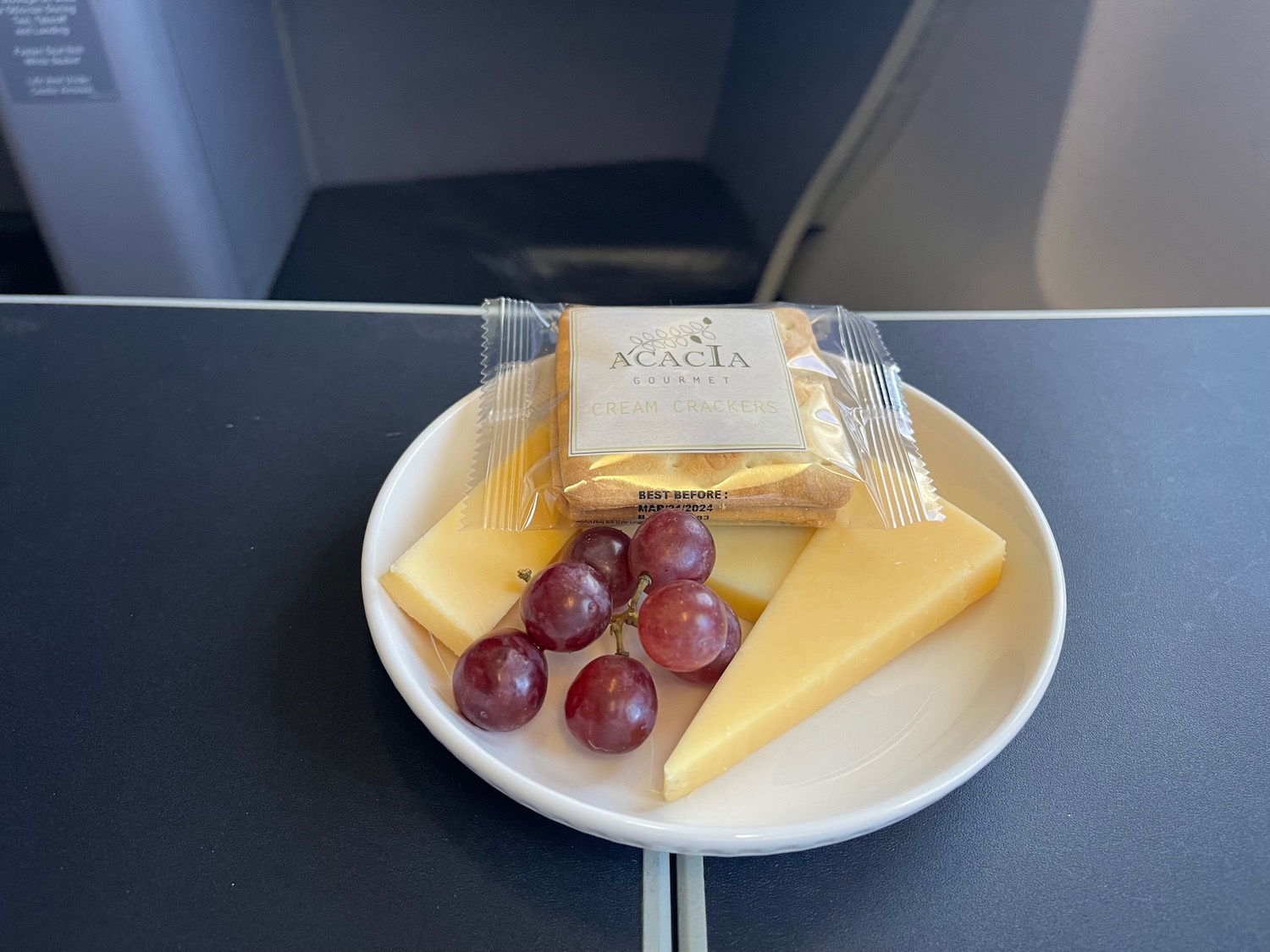 a plate of cheese and grapes on a table