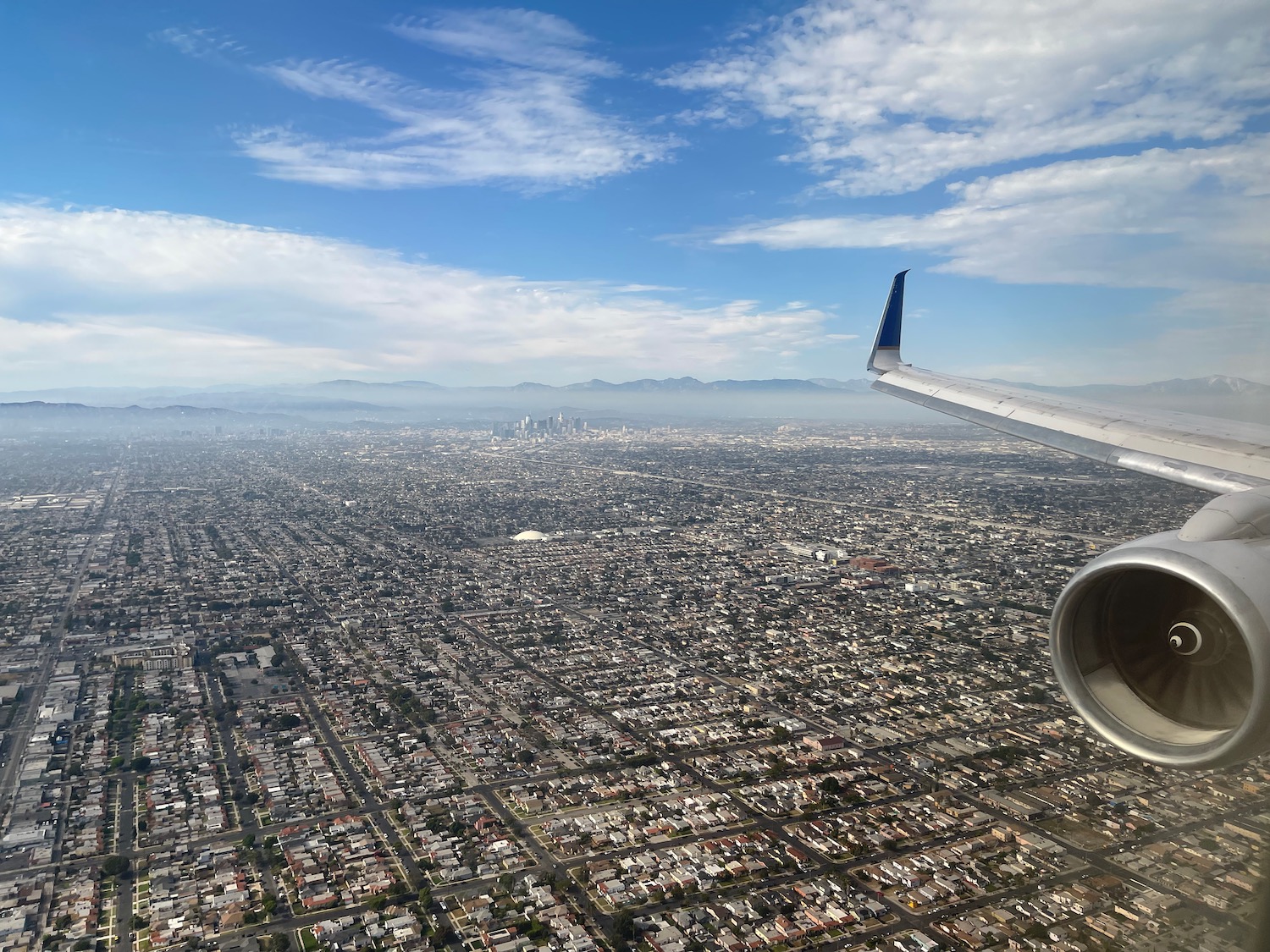 an airplane wing and wing of an airplane flying over a city