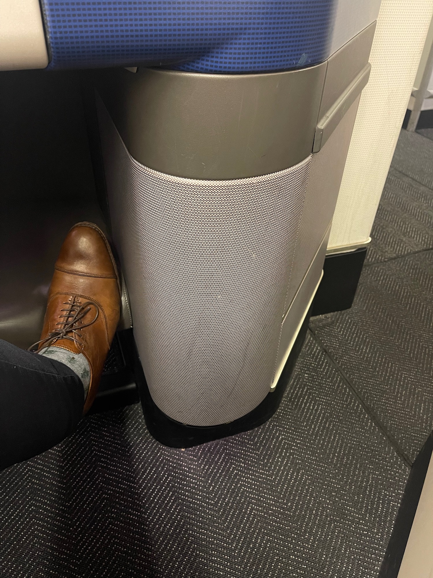 a person's foot next to a trash can