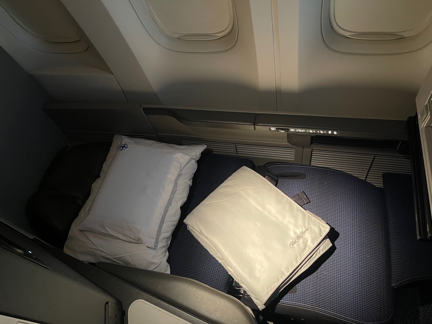 a seat with pillows and a white pillow on it