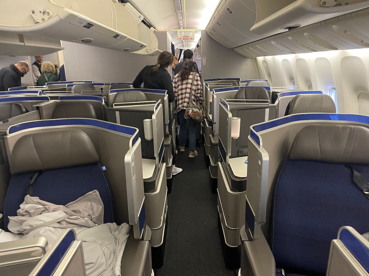 people in an airplane with seats and people walking