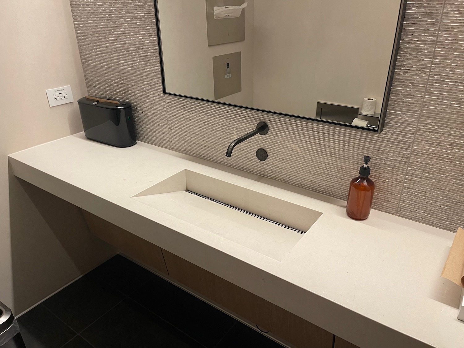 a bathroom sink with a mirror and a bottle of soap