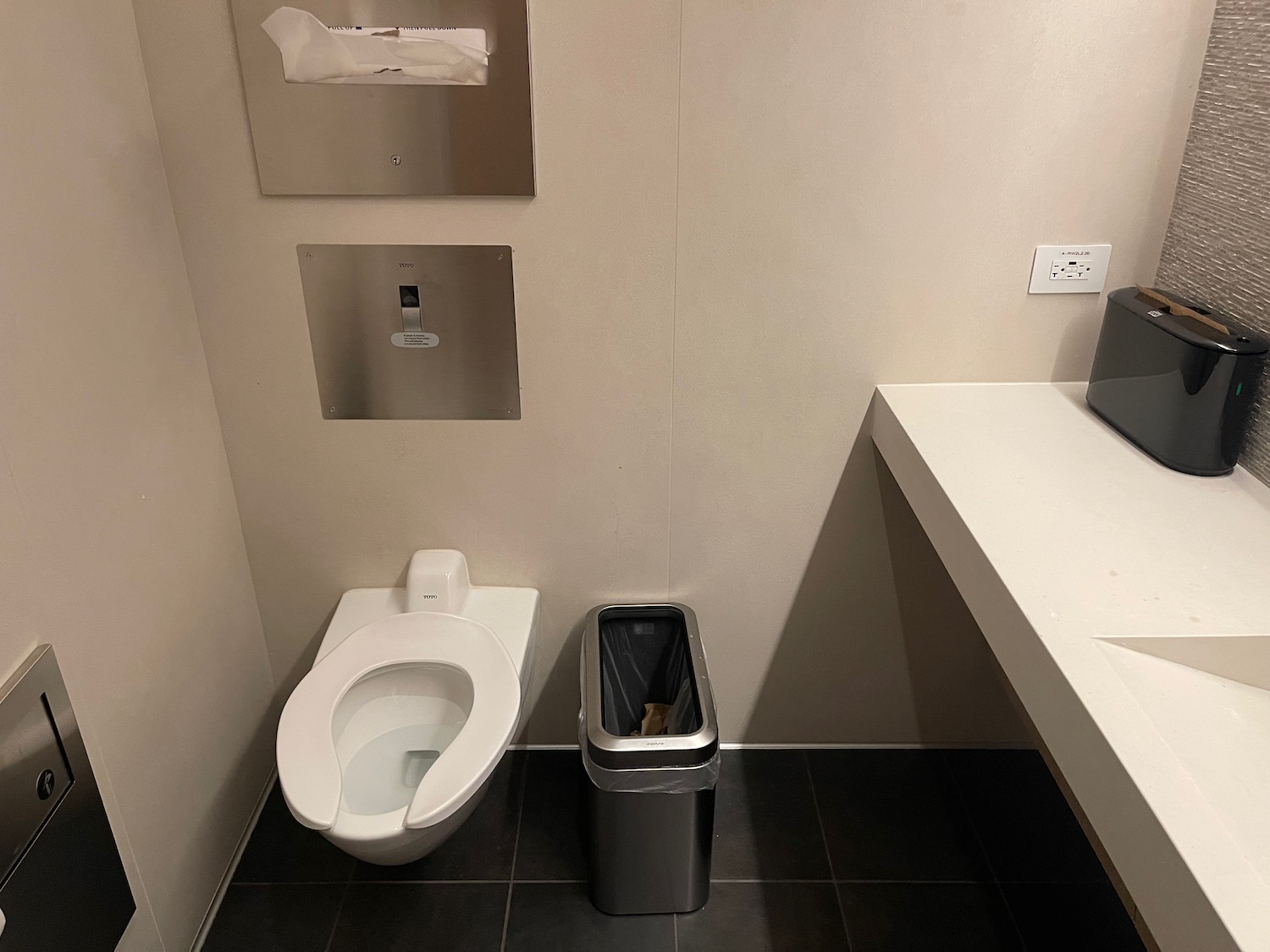 a toilet and trash can in a bathroom