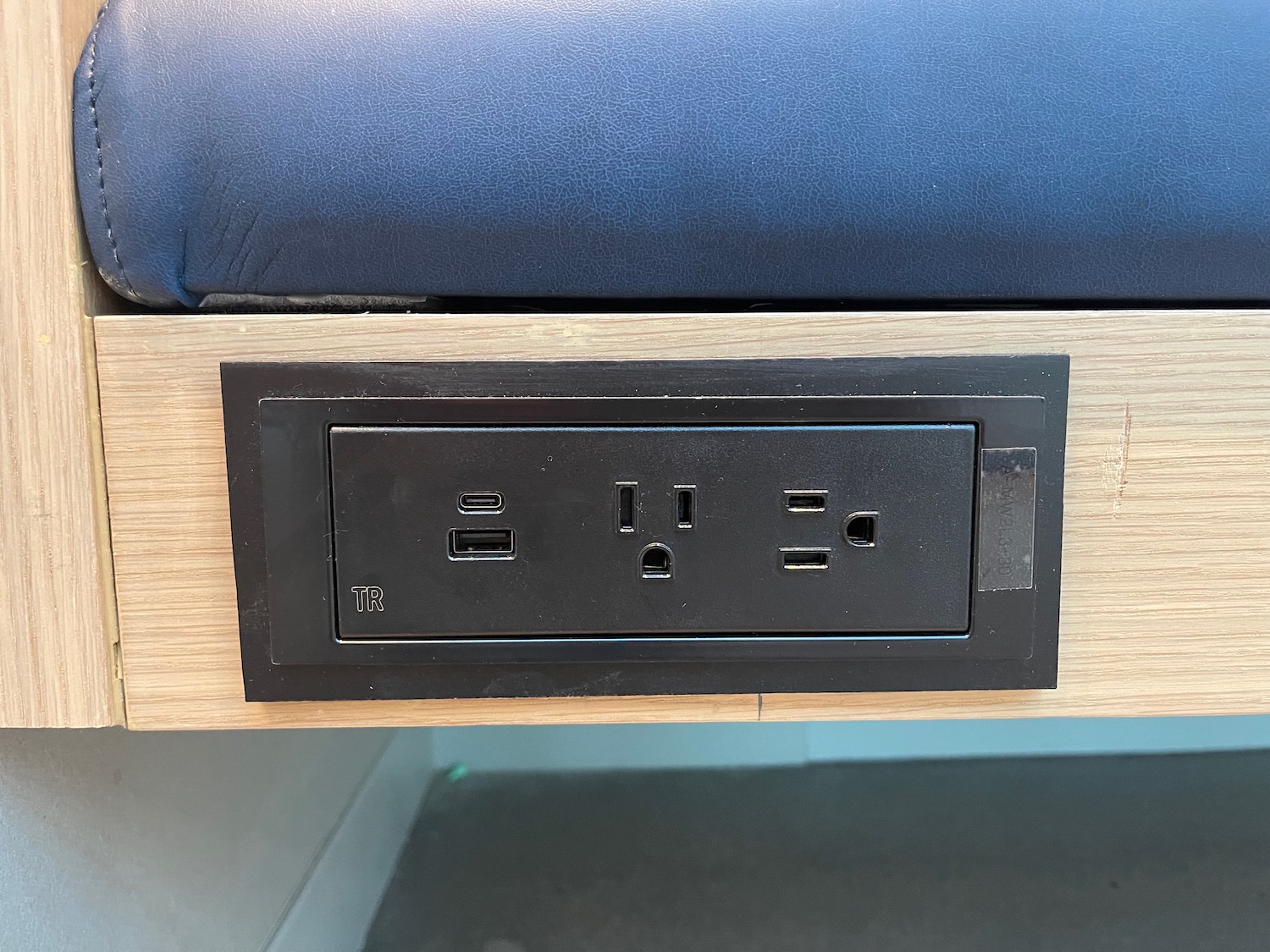 a black electrical outlet on a wood surface