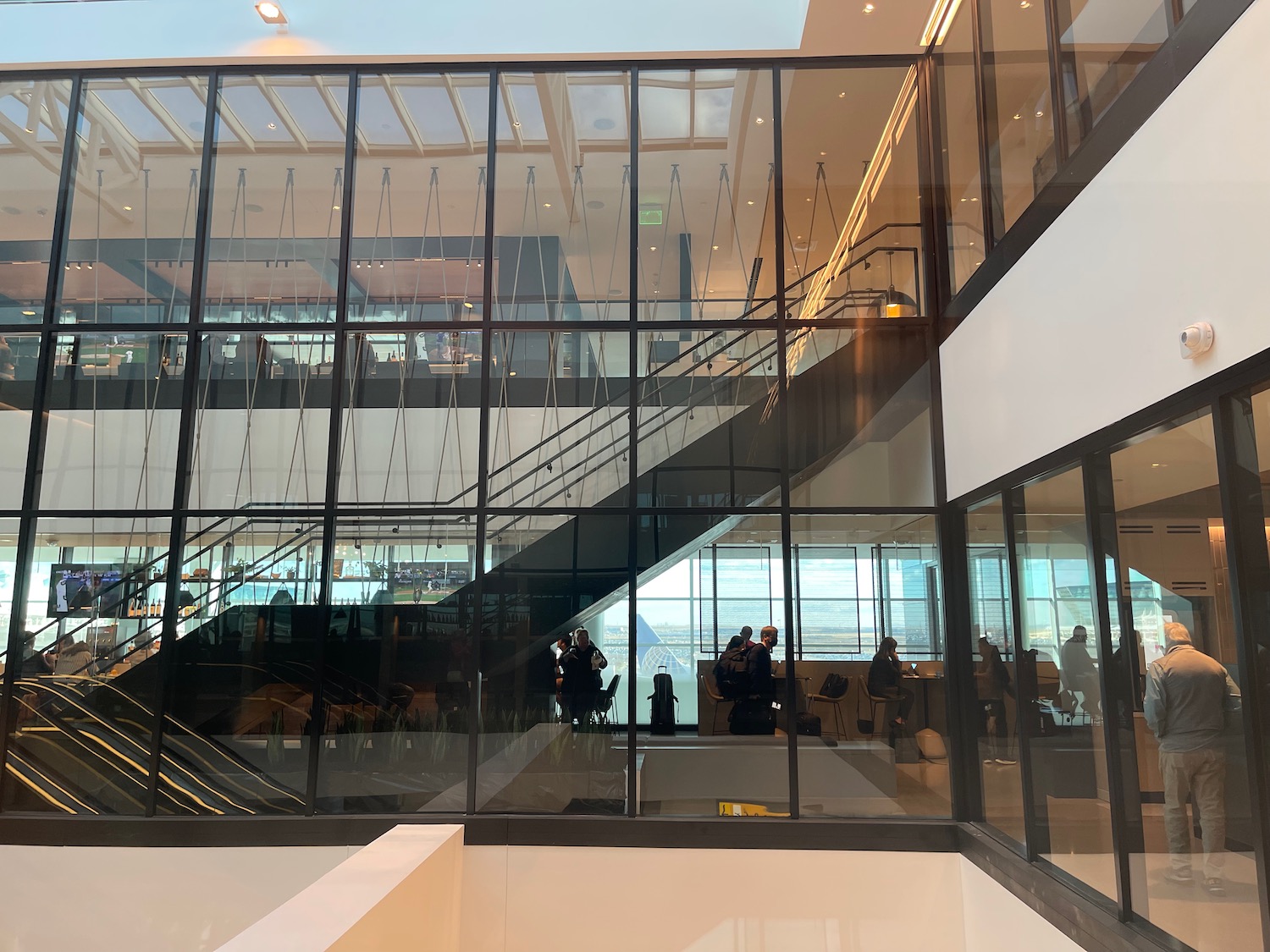 a glass wall with people walking in it