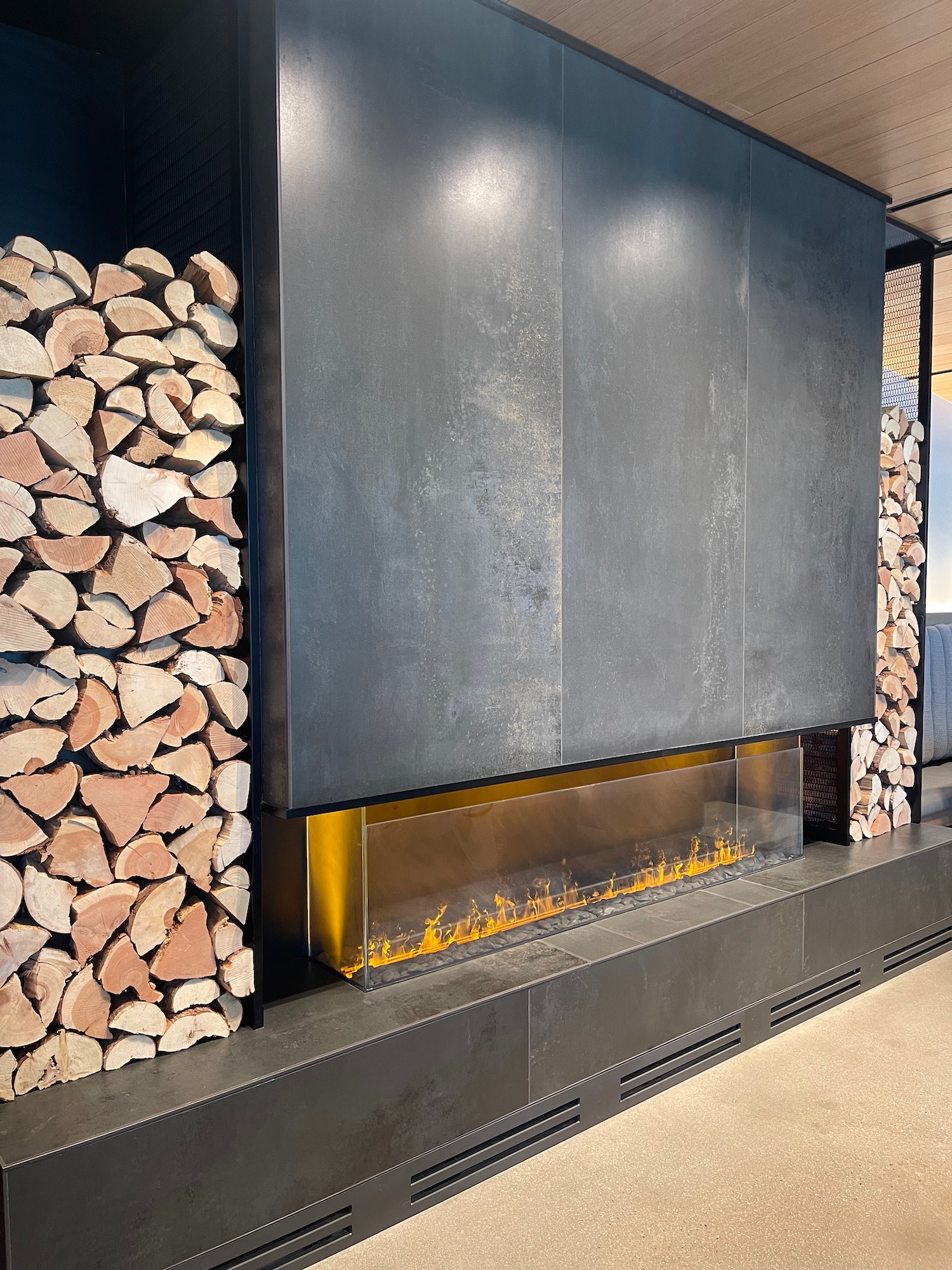 a fireplace with firewood stacked in front of it