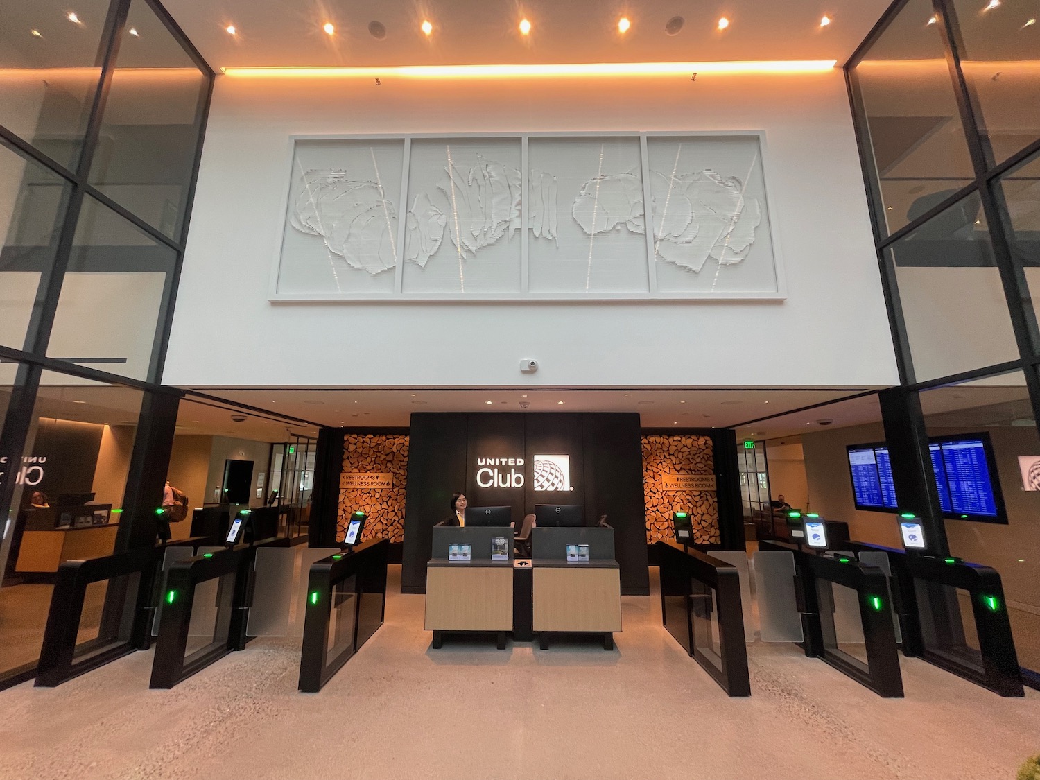 a lobby with a large white wall and a large picture on the wall