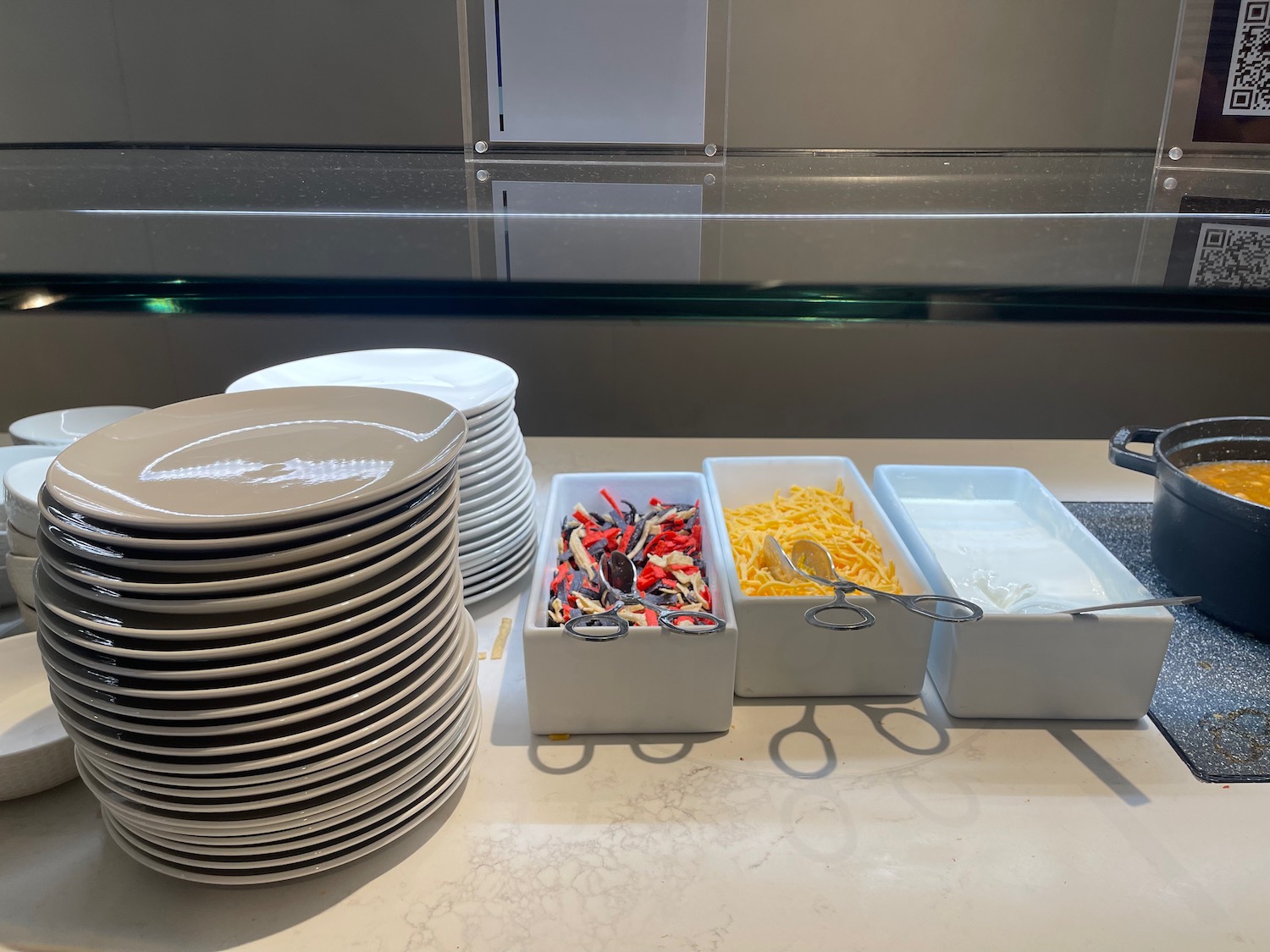 a stack of plates and bowls with food items in containers