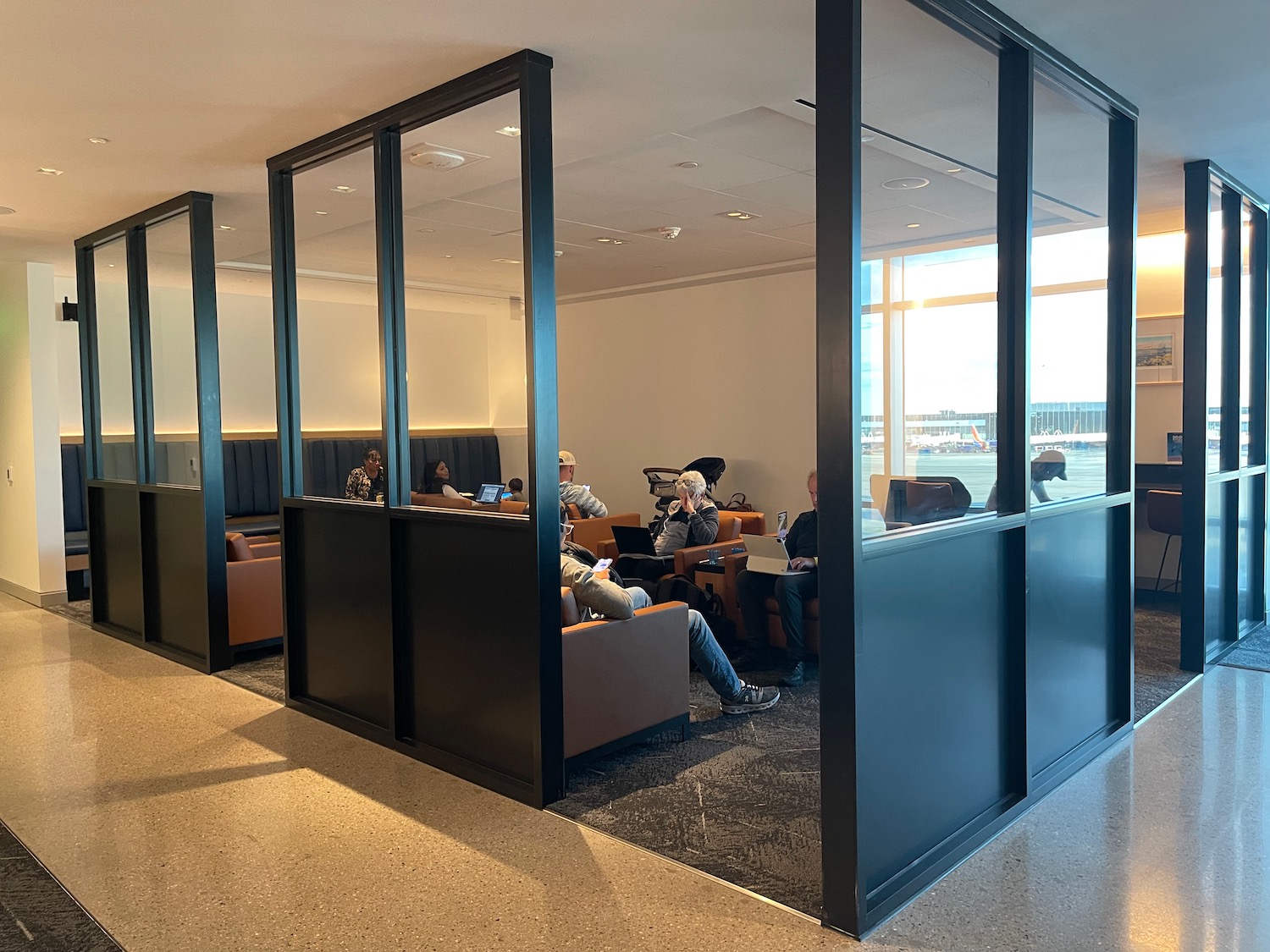 a group of people sitting in chairs in a room with glass walls