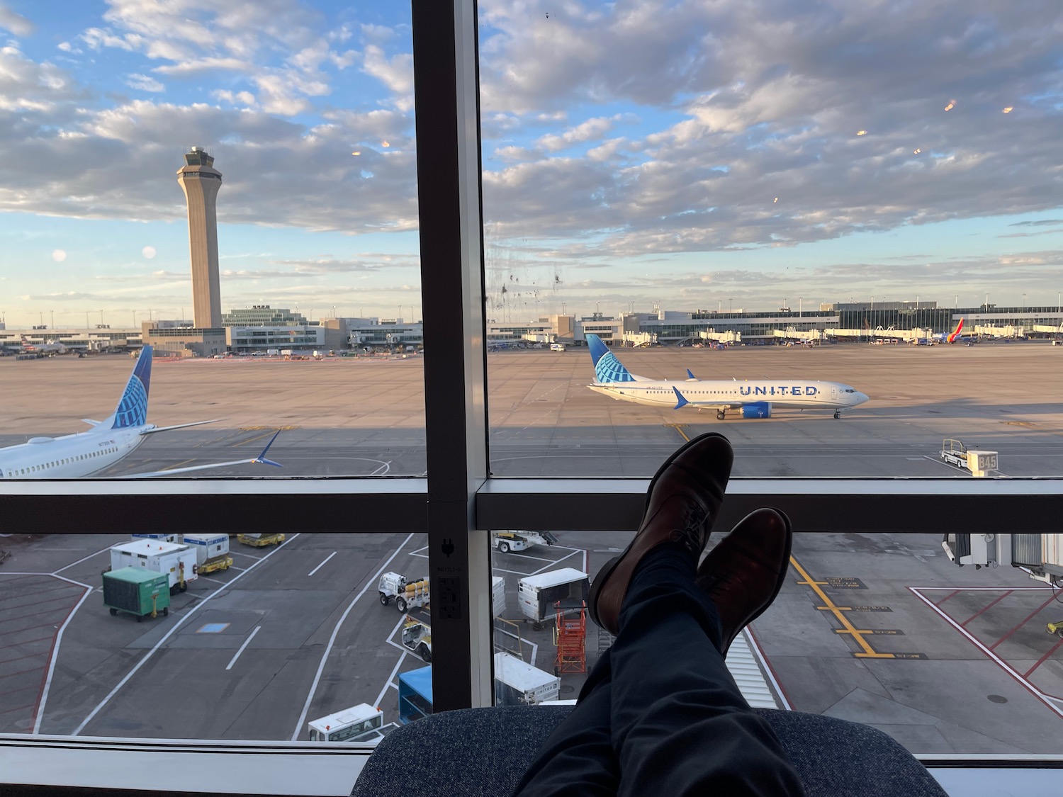a person's legs in front of a window with airplanes in the background