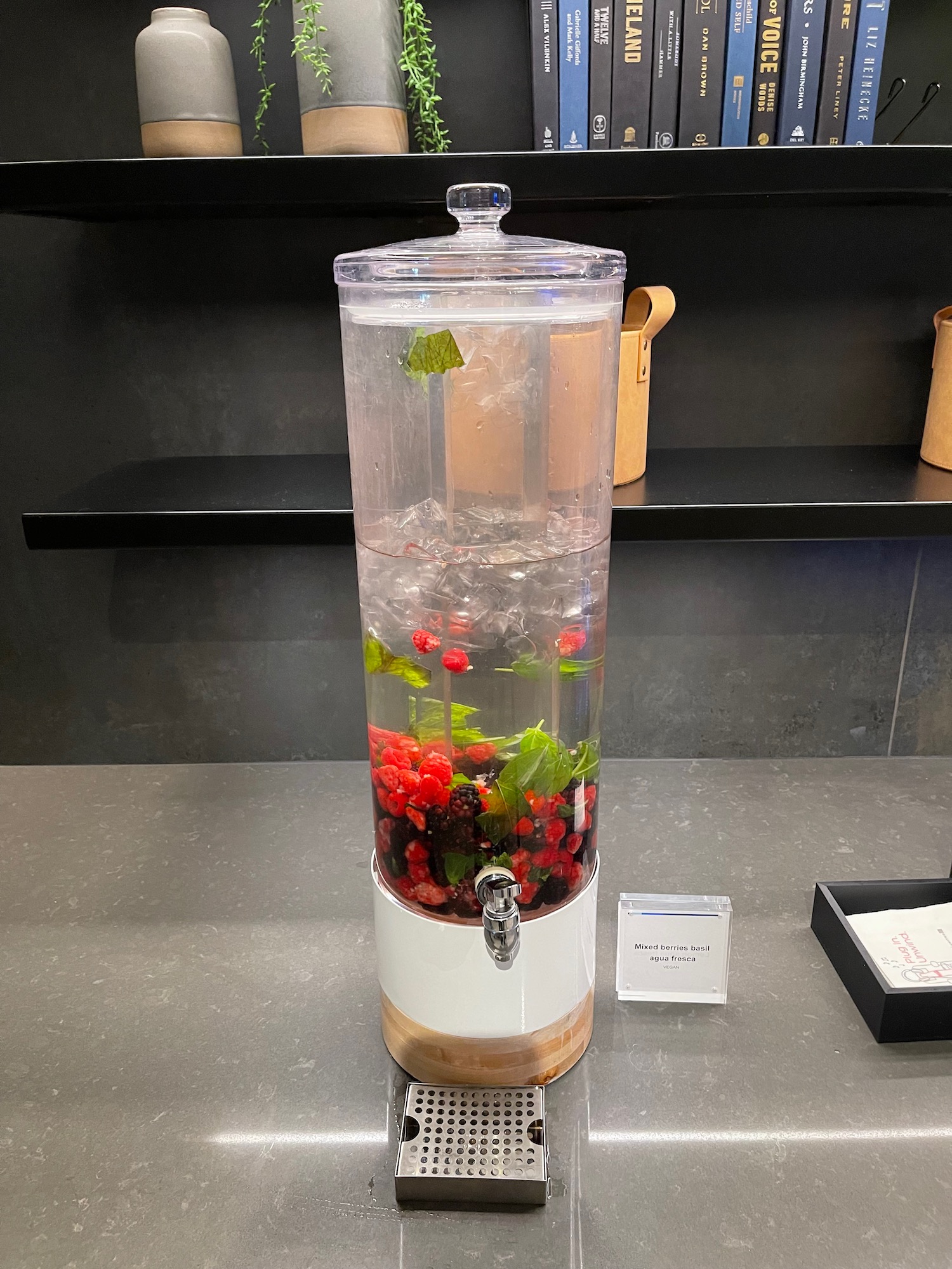 a water dispenser with berries and mint in it