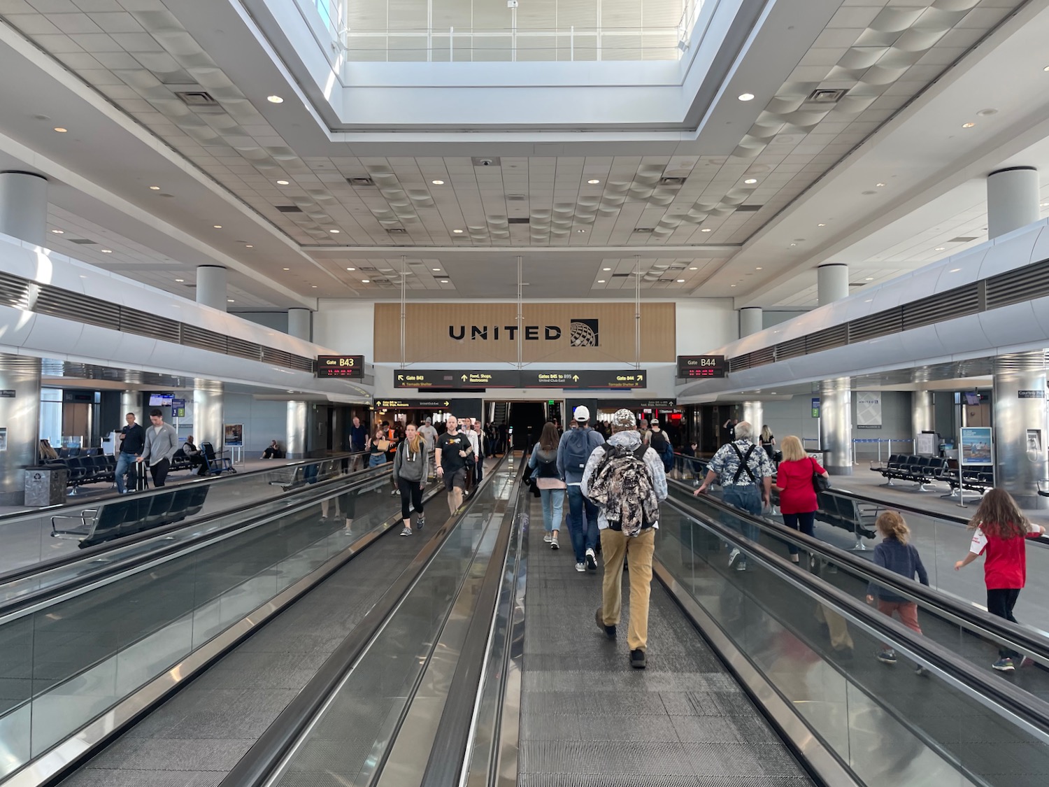 people walking on an escalator in a terminal