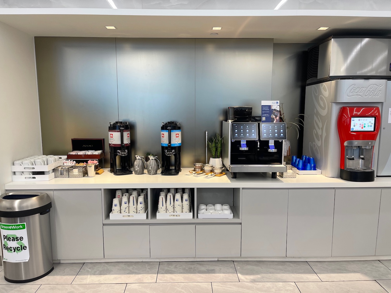 a coffee machine and soda machines on a counter