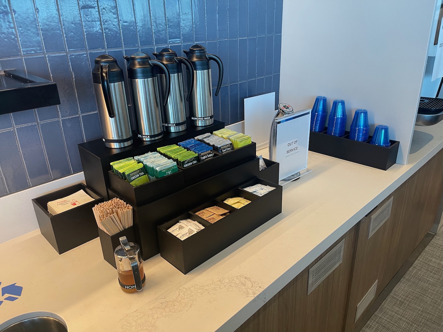 a counter with a variety of coffee containers and a coffee pot