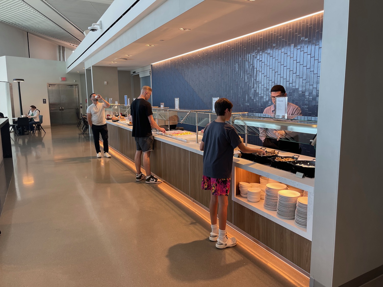 a group of people standing in a line at a buffet