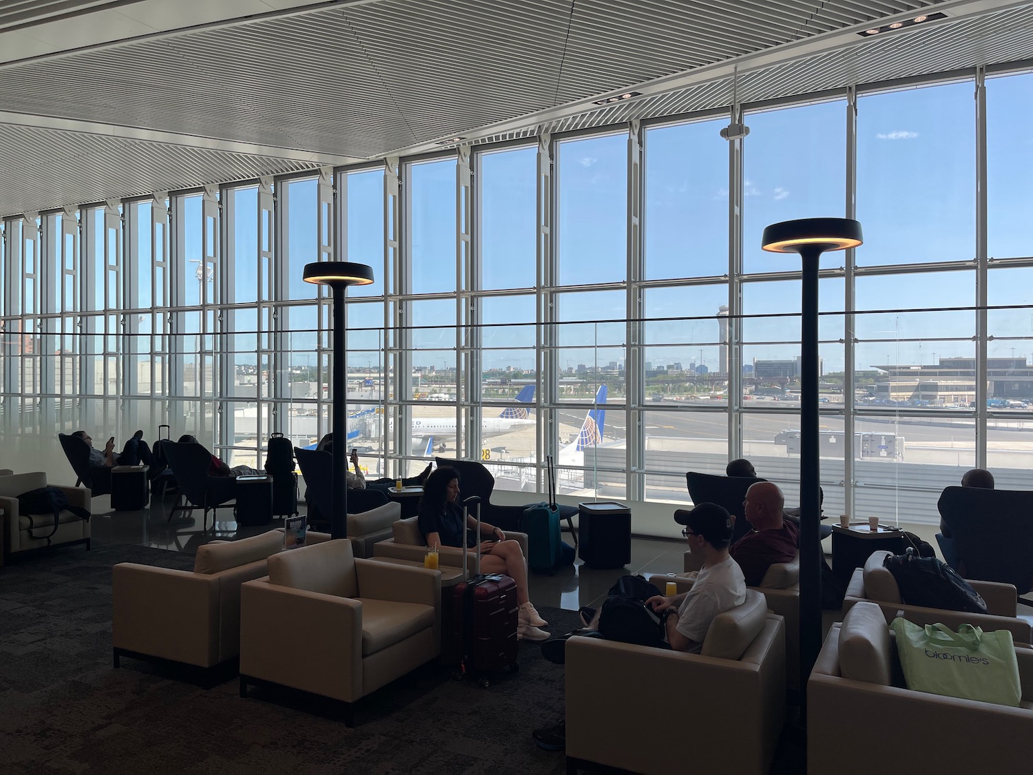 people sitting in a lounge area with a large window