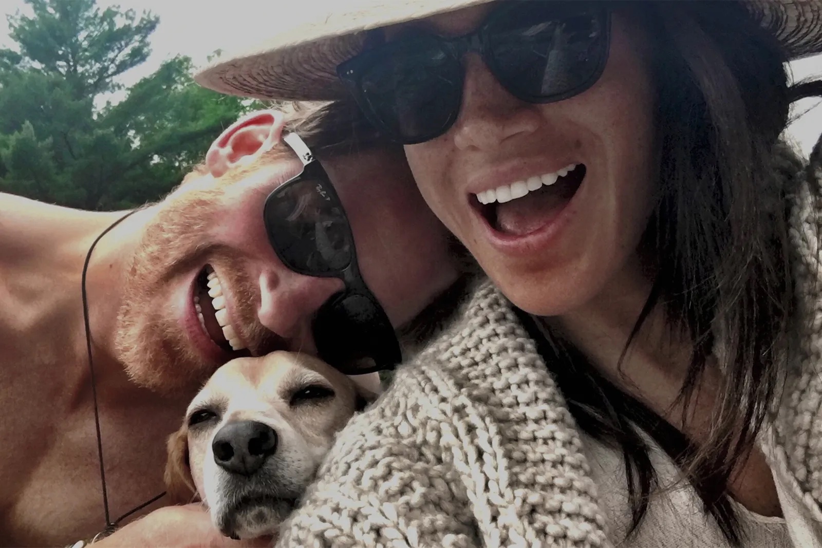 a man and woman taking a selfie with a dog