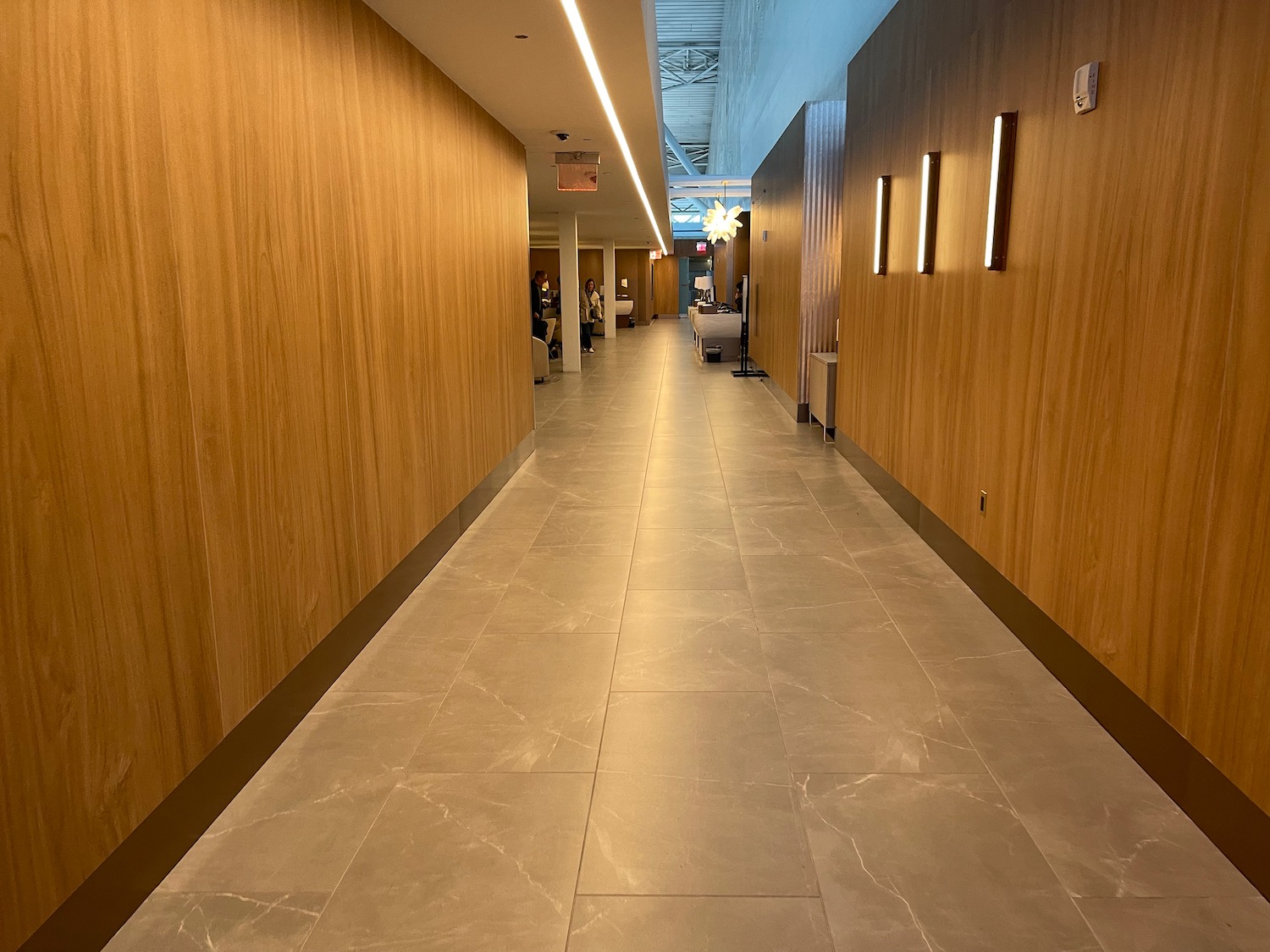 a long hallway with wood walls and lights