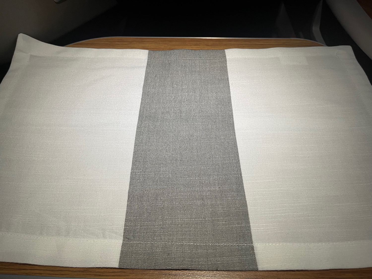 a white and black striped place mat on a wooden table