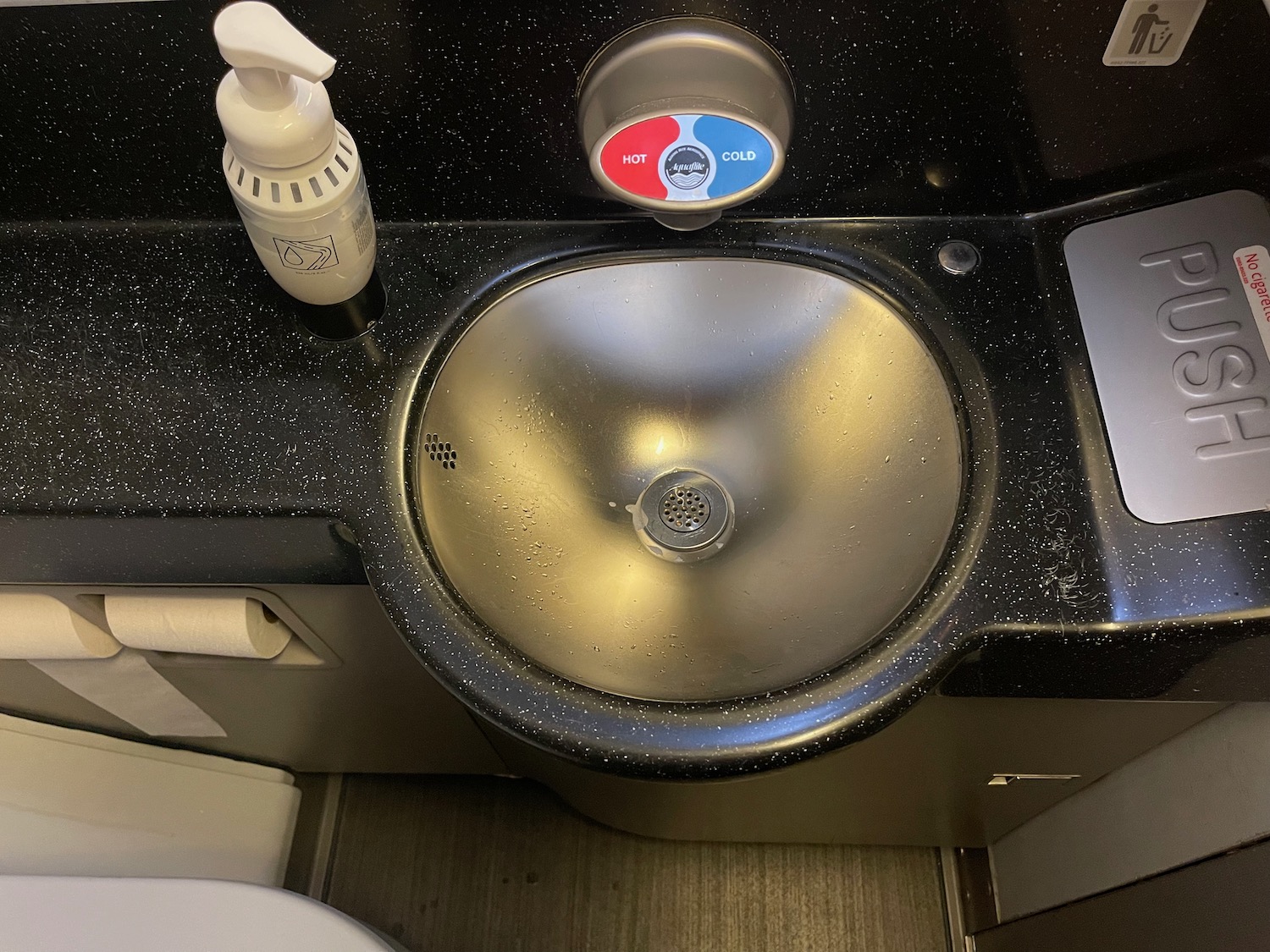 a sink with a bottle of liquid and a white bottle on the counter