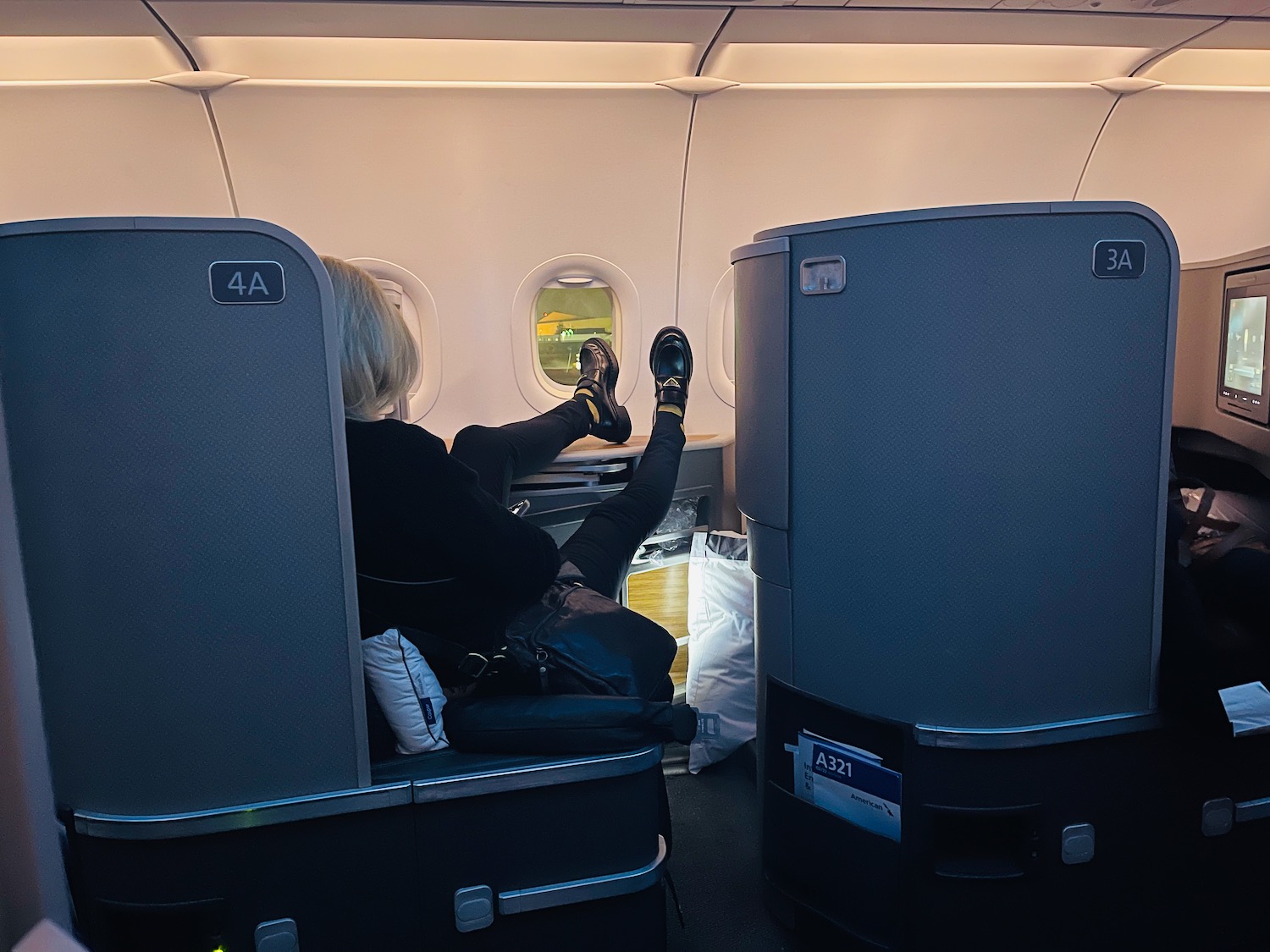 a woman sitting in an airplane with her feet up