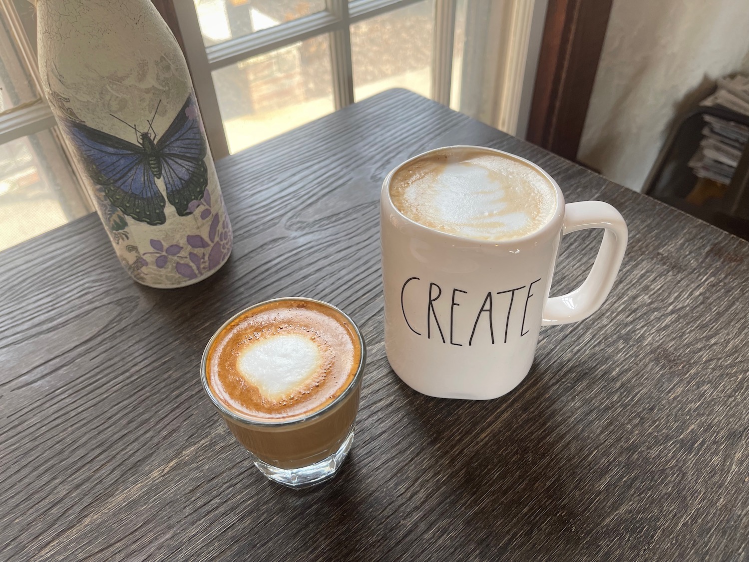 a coffee mug and a glass of coffee on a table