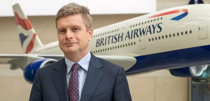 a man in a suit and tie standing in front of a plane