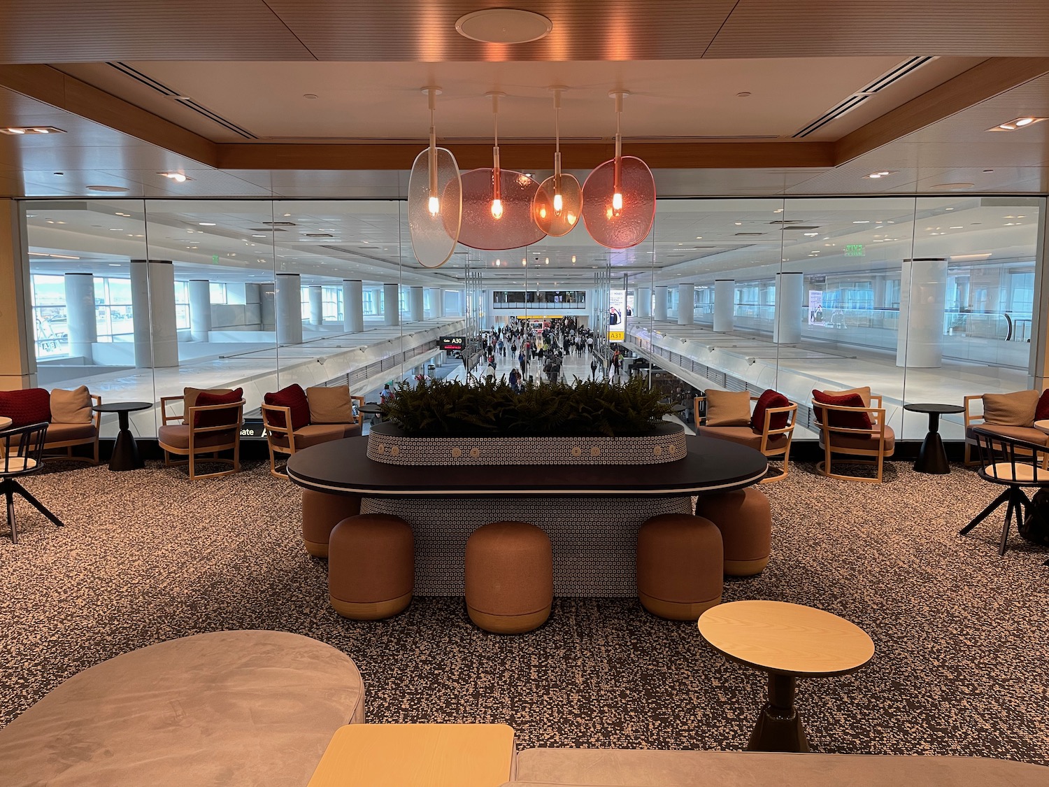 a room with a large mirror wall and a large table with chairs and a plant