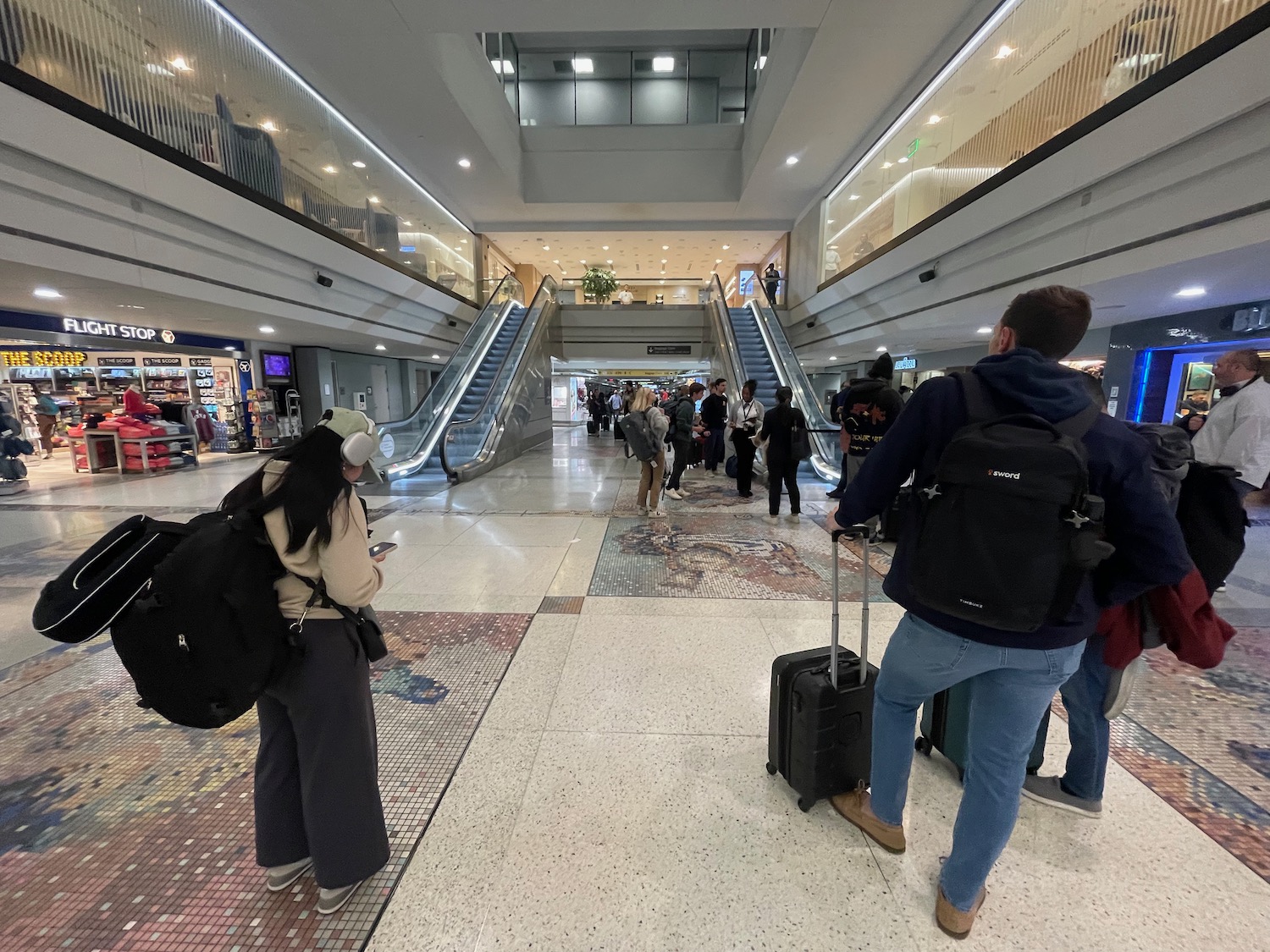 people standing in a large building with escalators