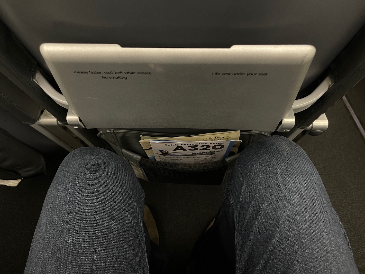 a person's legs and a pocket on a seat