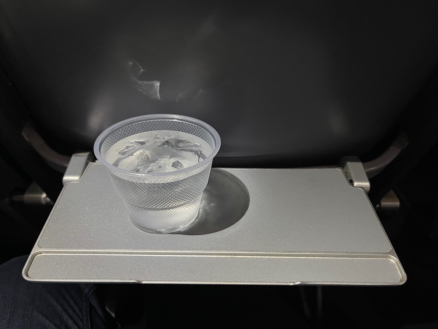 a plastic cup with ice on a tray