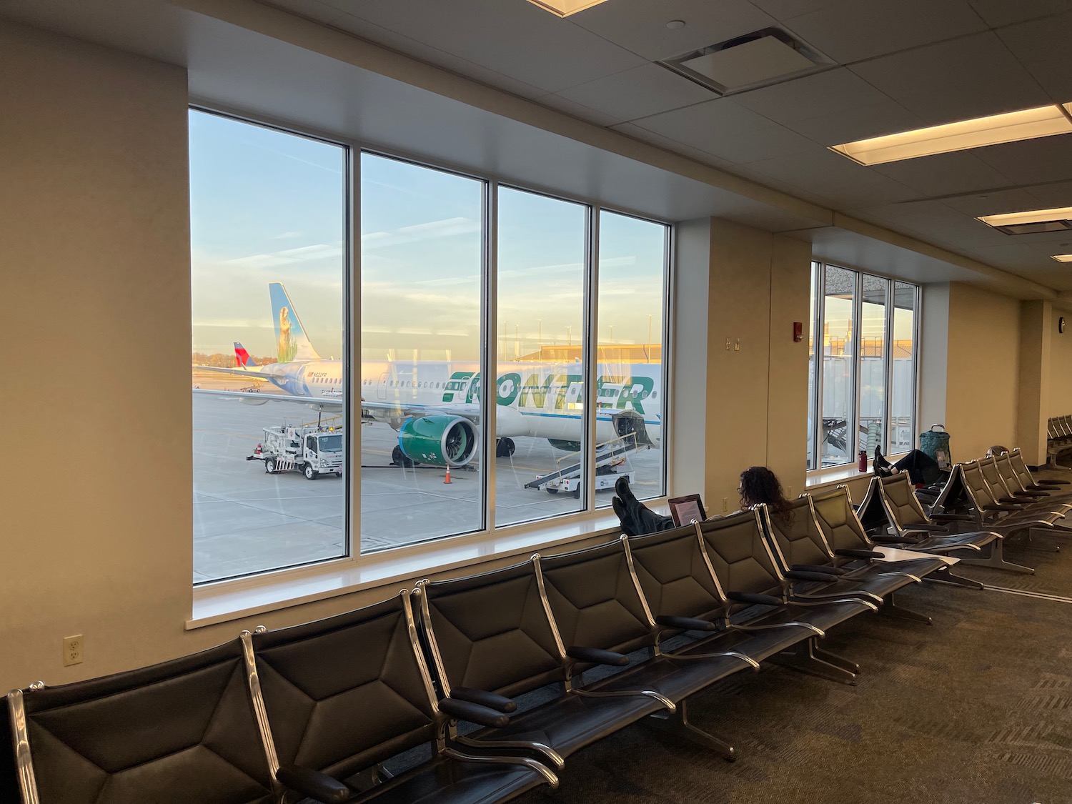 a group of people sitting in a row of chairs in an airport